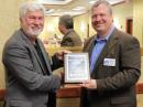ARRL CEO Howard Michel, WB2ITX (left), presents a plaque to  MRAC Club President David Schank, KA9WXN, on behalf of the ARRL Central Division, to recognize the club's 100th anniversary of ARRL affiliation.